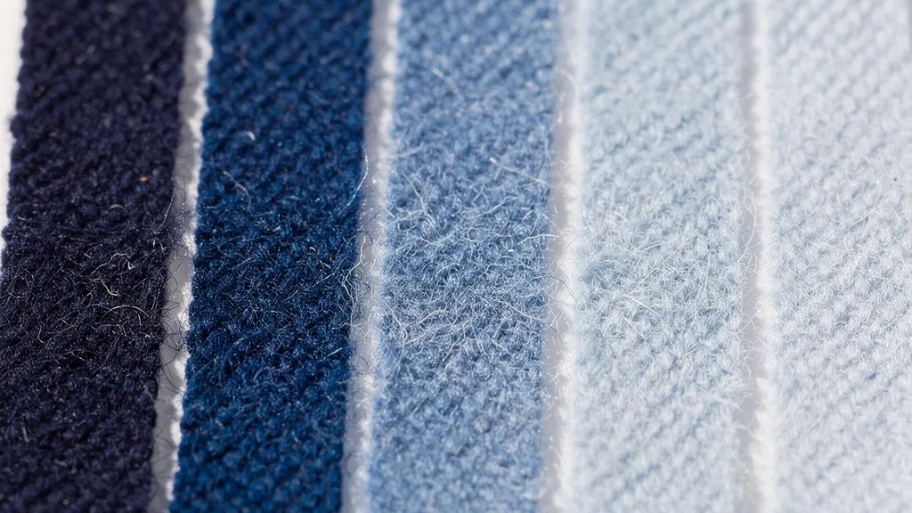 Extreme close-up of Blue Wool standard test strips showing a gradual color fading gradient from deep blue to pale white.